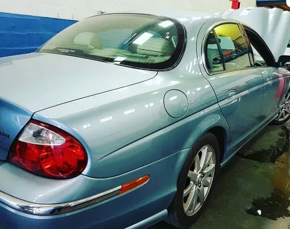 A light blue Jaguar S-Type in the workshop